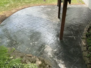 Charcoal slate textured stamped concrete patio in a herringbone pattern, by NG Masonry serving Fairport NY