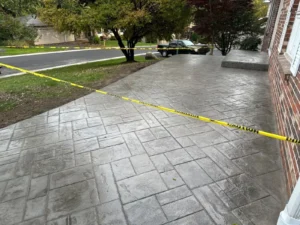 Wide ashlar slate stamped concrete driveway at a red brick home, by NG Masonry serving Penfield NY