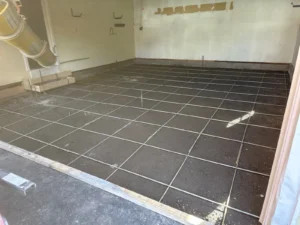 Rebar grid laid over compacted subbase inside a garage prepped for a concrete floor pour, by NG Masonry serving Marion NY